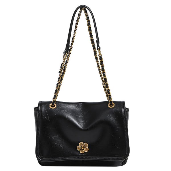 Structured flap shoulder bag with antique gold-tone chain strap and flower turn-lock clasp in crinkled leather-look finish