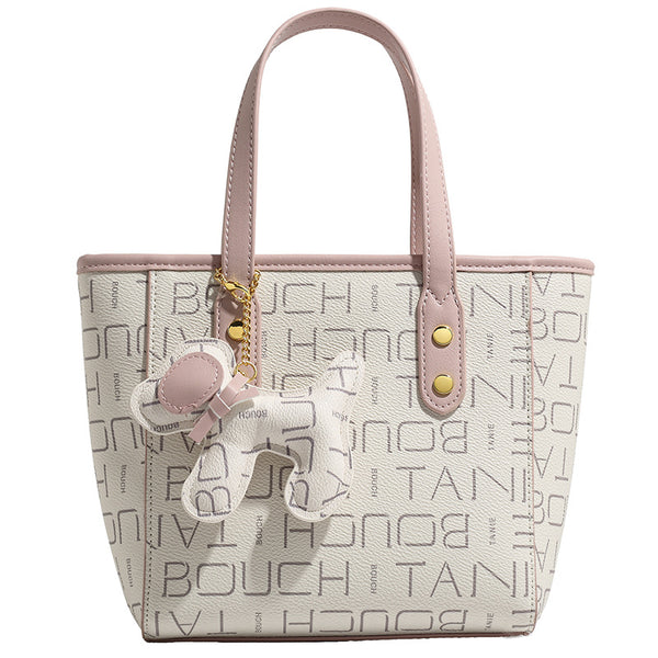 Kleine strukturierte Mini-Tote-Bag mit Logoprint, zartrosa Besatz, goldfarbenen Beschlägen, zwei oberen Henkeln und baumelndem Bärenanhänger