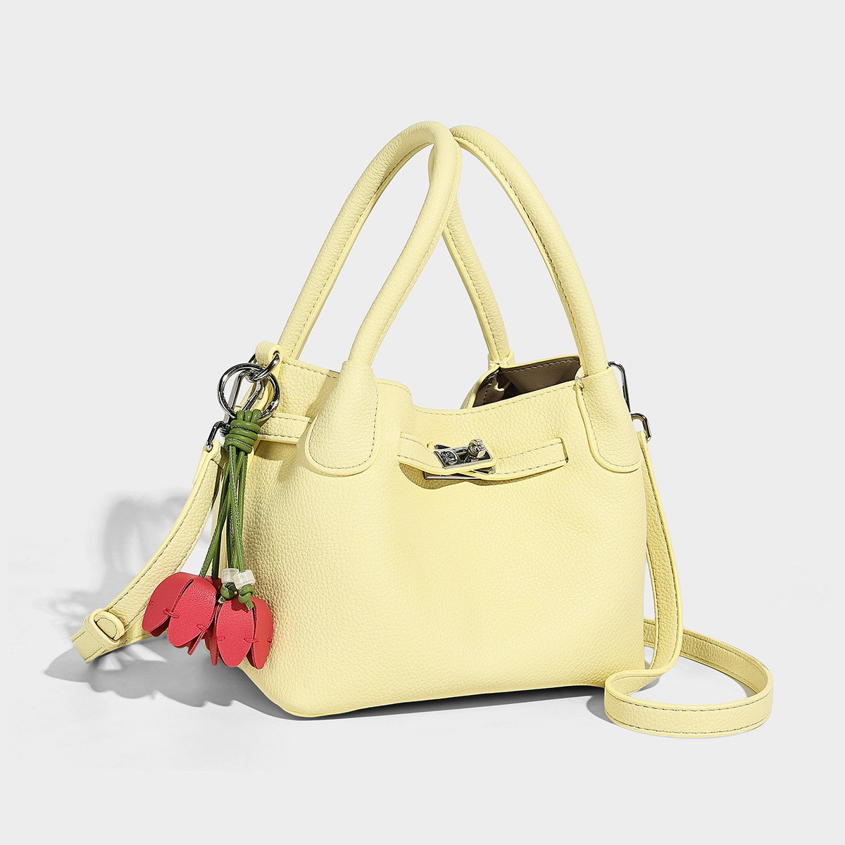Small structured pebbled-finish tote bag with silver turnlock closure, dual top handles, detachable shoulder strap, and