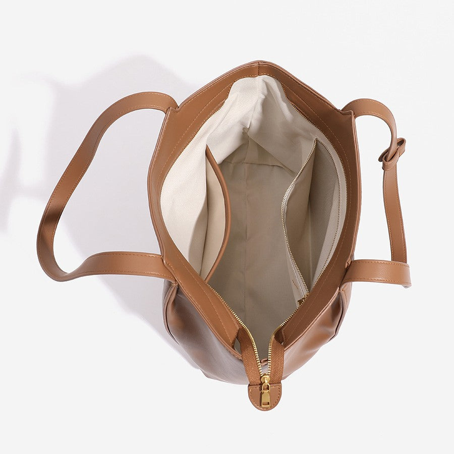 Strukturierte Tote-Bag in Lederoptik mit offenem oberen Abschluss, langen Schulterriemen und goldfarbenem, rundem Emblem-Beschlag, Detailansicht 4