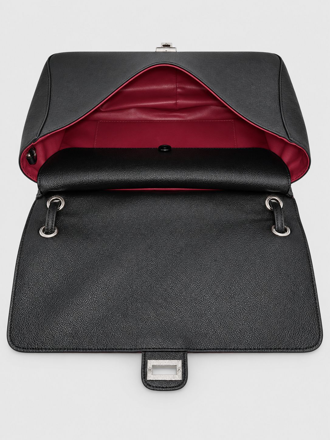 Structured black flap shoulder bag with pebbled texture, silver-tone turn-lock closure, and adjustable single shoulder strap