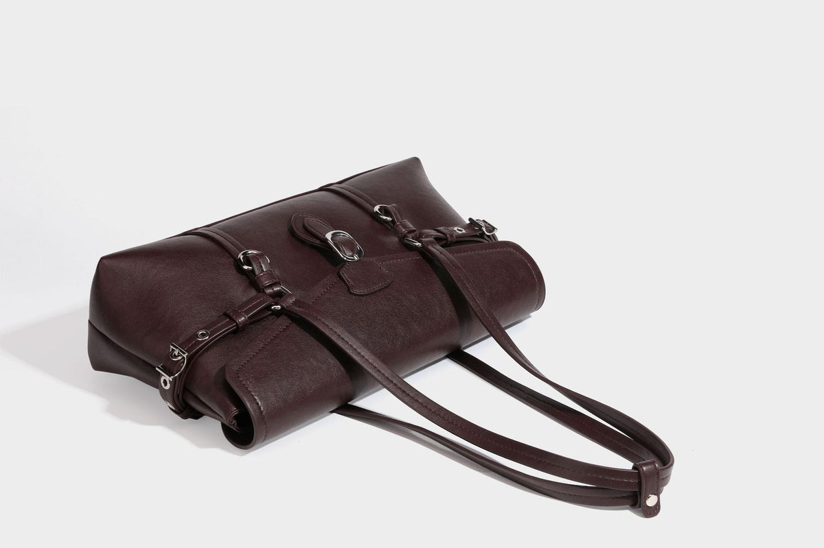 Strukturierte rechteckige Schultertasche mit Überschlagverschluss, vorderem Schnallengurt-Detail und ringförmigen Beschlägen in