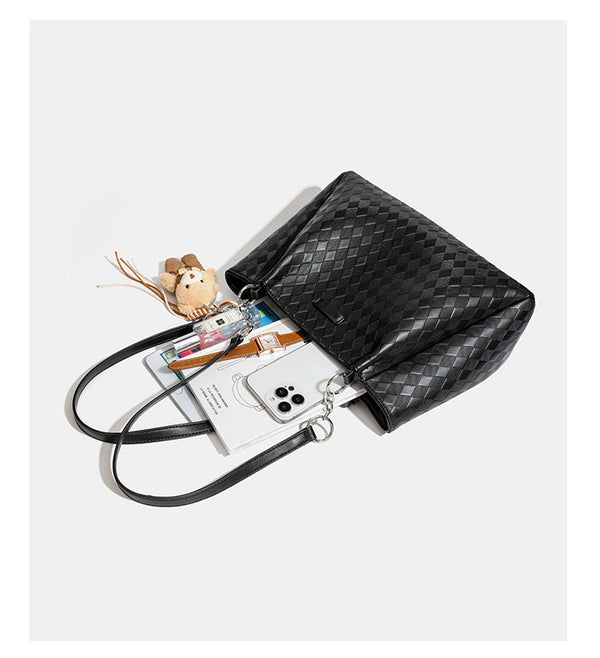 Black diamond-quilted leather-look tote bag with silver chain-ring shoulder straps and plush bear charm pendant, detail view