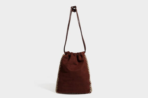 Matte suede-look drawstring bucket bag with cream braided woven edge trim and slim adjustable leather-look shoulder strap
