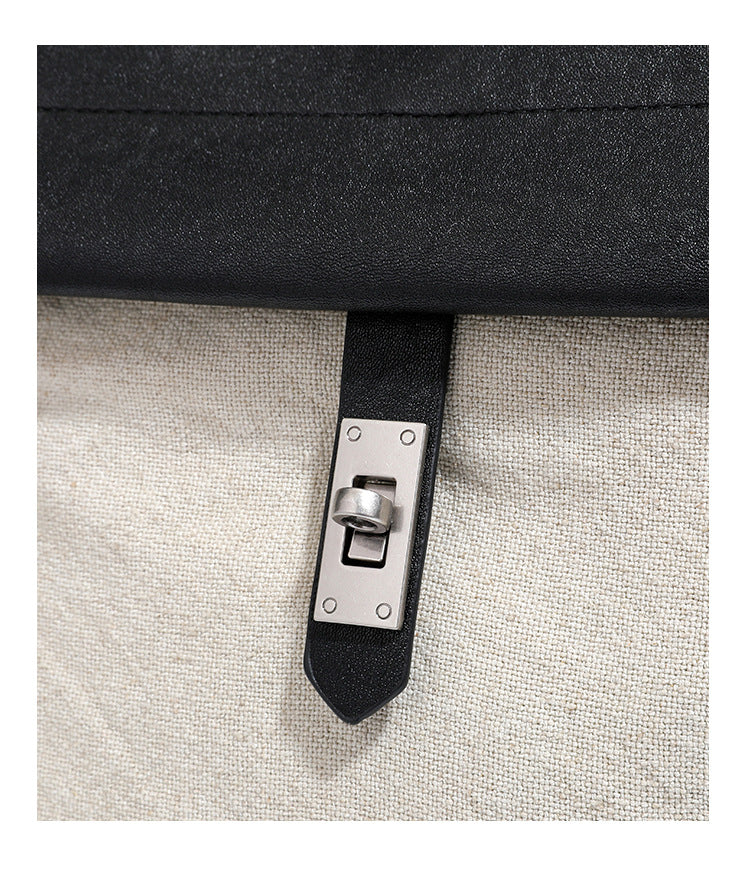 Strukturierter beigefarbener Rucksack aus gewebtem Canvas mit schwarzer Klappe in Lederoptik, Drehverschluss, Tragegriff und flachem Schulter