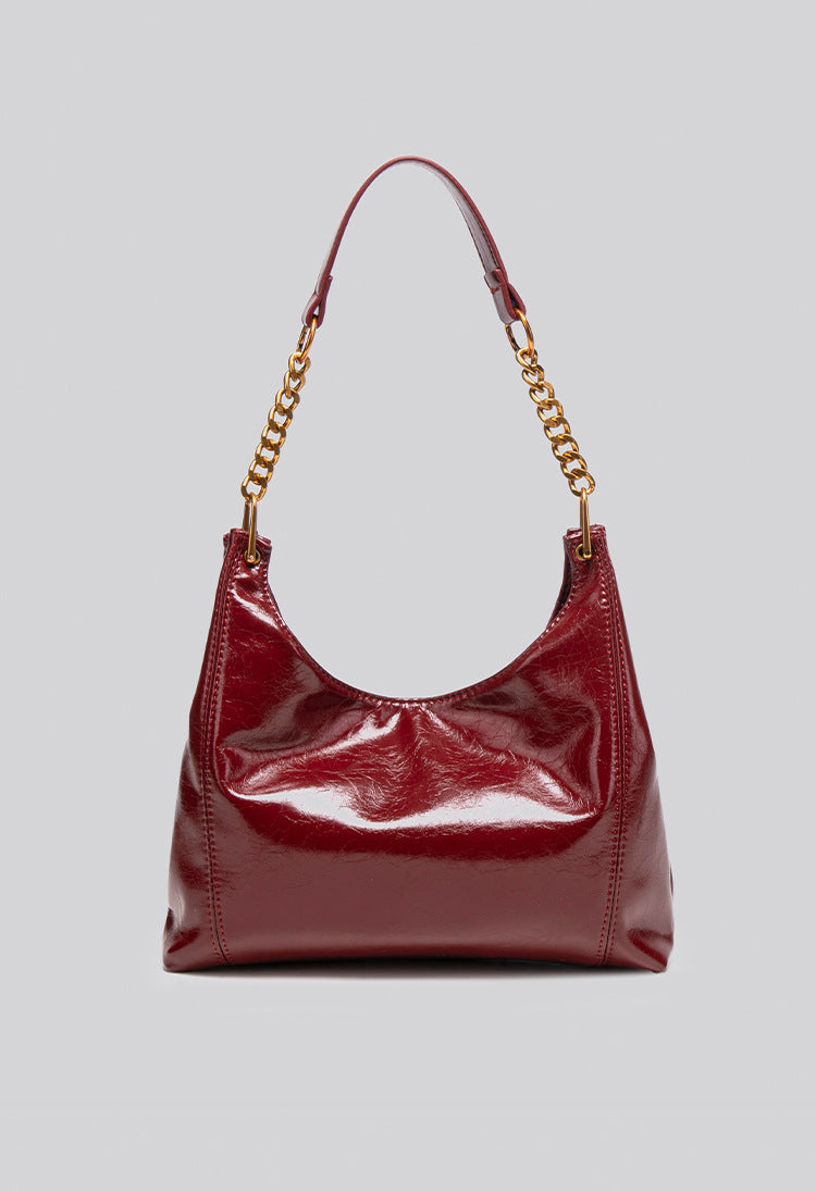 Glossy leather-look hobo shoulder bag with gold-tone chain-and-leather strap in deep burgundy red, detail view 11
