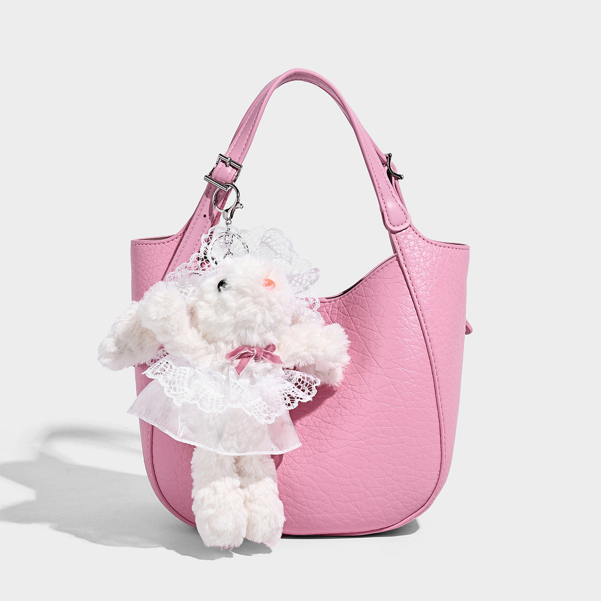 Small pebbled half-moon shoulder bag with dual top handles, detachable crossbody strap, and silver-tone hardware, detail view