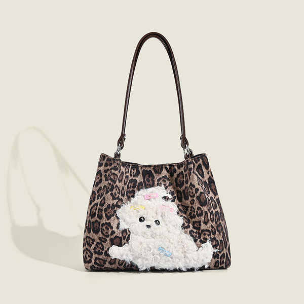 Leopard-print fabric tote bag with white plush teddy bear appliqué and brown leather-look shoulder straps, front view