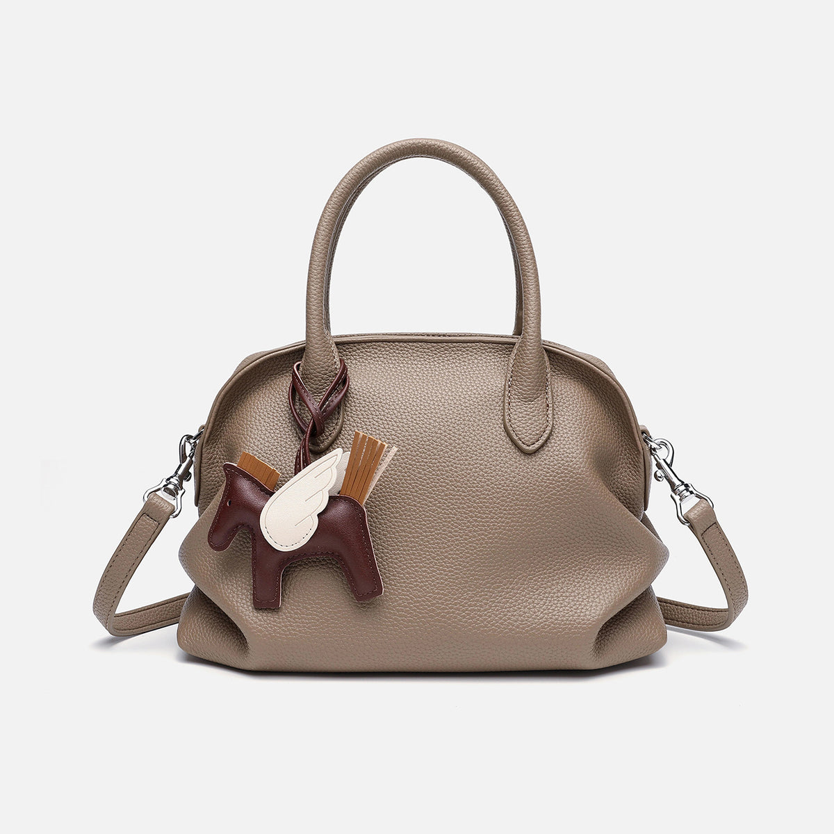 Rounded dome shell handbag in pebbled leather-look finish with twin top handles, zip closure, decorative horse charm, and