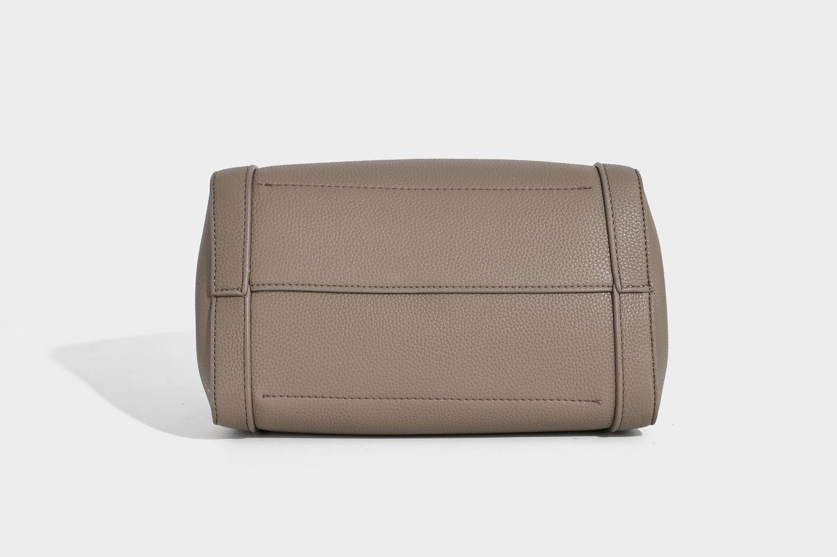 Structured trapezoid tote bag in taupe pebbled leather-look finish with gold-tone turn-lock hardware, dual top handles, and