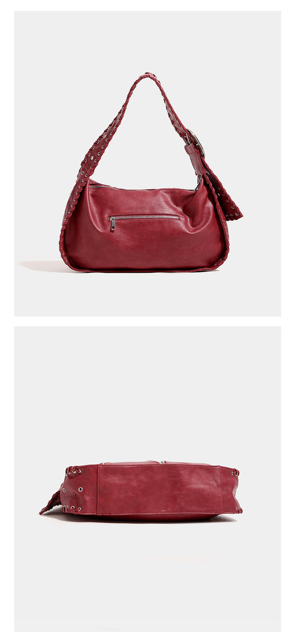 Slouchy hobo shoulder bag with wide braided eyelet strap, multiple front zip compartments, and silver-tone ring buckle