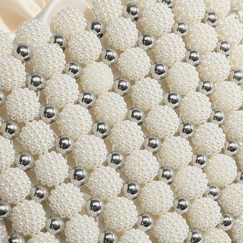 Small boxy pearl-bead mini top-handle bag with silver metallic bead accents, satin floral detail, and long beaded shoulder
