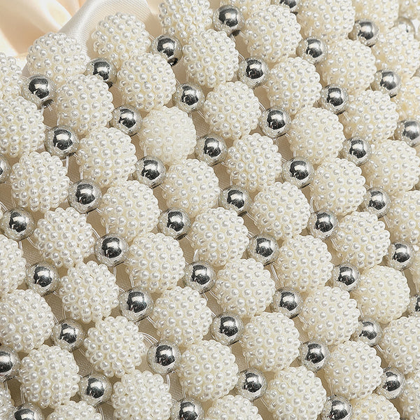 Small boxy pearl-bead mini top-handle bag with silver metallic bead accents, satin floral detail, and long beaded shoulder