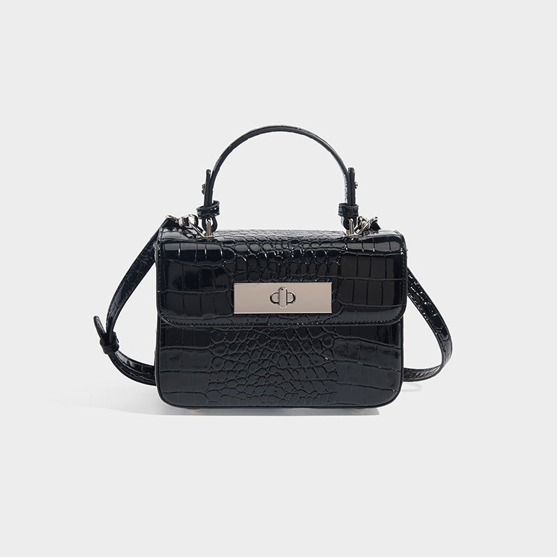 Small structured rectangular satchel with glossy crocodile-embossed finish, arched top handle, front flap, and silver-tone