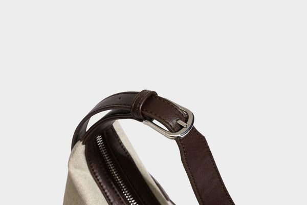 Lässige Hobo-Schultertasche aus haferfarbenem Canvas mit dunkelbraunen Besätzen in Lederoptik, silberfarbenem Reißverschluss und langem, verstellbarem