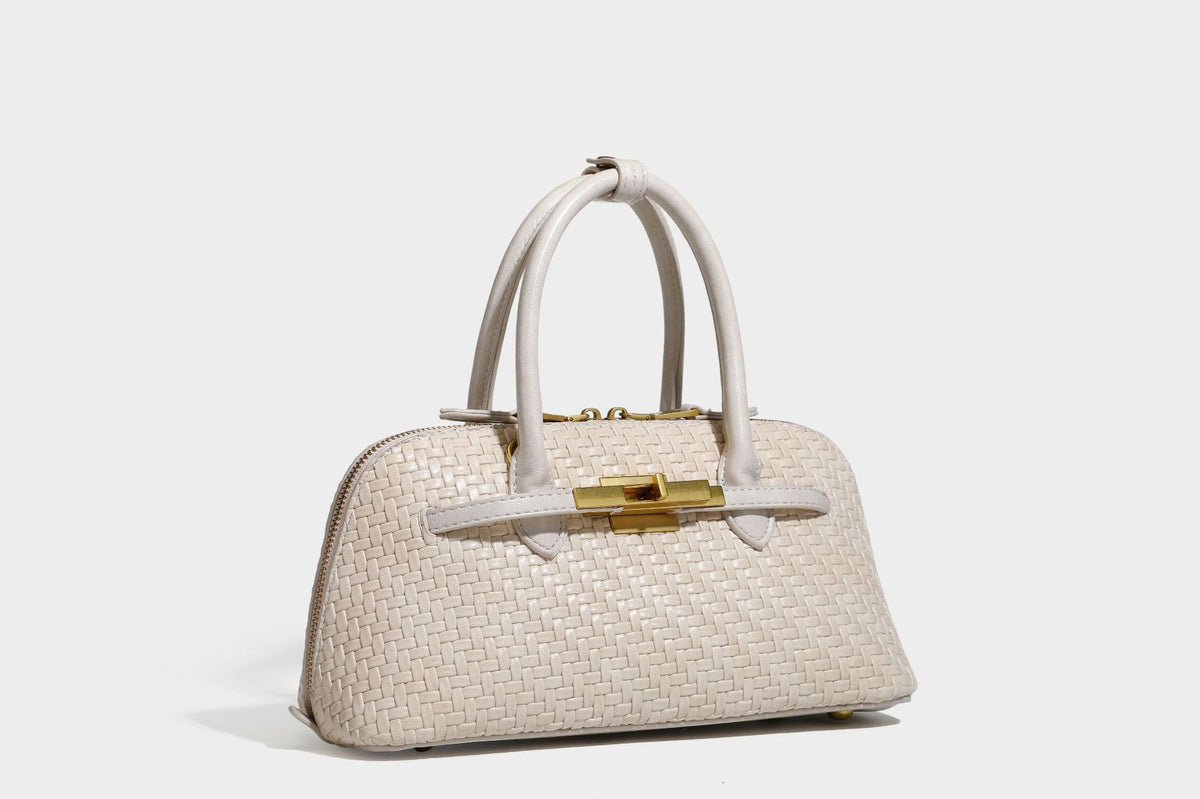Structured woven-embossed leather-look satchel with dual rolled top handles, gold-tone turn-lock closure, and detachable