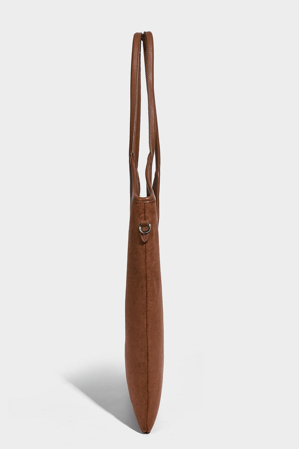 Tote-Bag in warmem Braun mit matter Wildlederoptik, langen Tragegriffen, geprägtem Logo, silberfarbenen Beschlägen und passendem, Detail