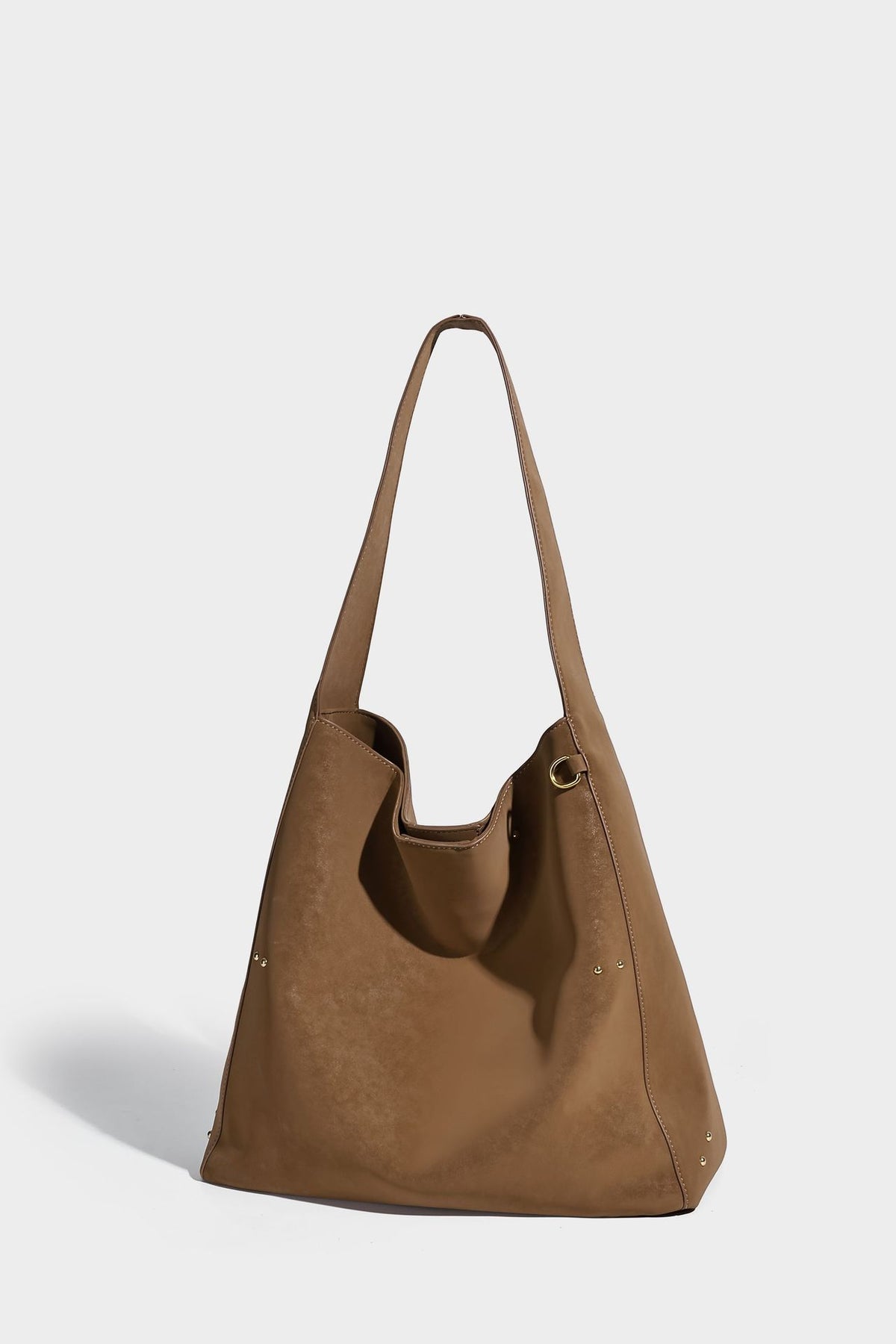 Oversized trapezoid tote bag with matte leather-look finish, gold-tone rivets, and long shoulder strap, detail view 13
