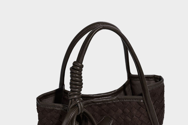 Strukturierte Tote-Bag mit gewebter Oberfläche, befestigtem Mini-Charm-Täschchen, geknoteten Tragegriffen und abnehmbarem Schulterriemen, Detailansicht