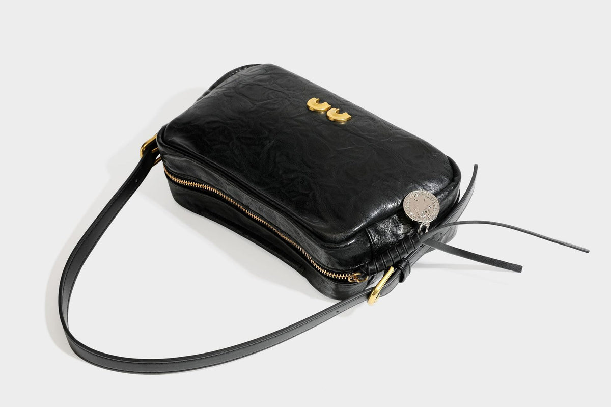Compact black crinkled leather-look baguette shoulder bag with gold-tone arch hardware and adjustable strap, detail view 32