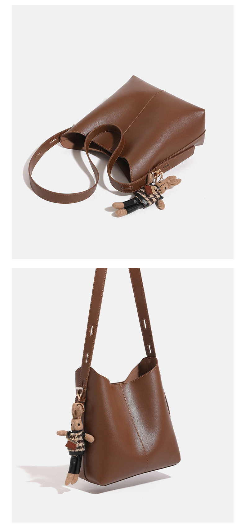 Smooth leather-look bucket bag with long flat shoulder strap, open top, gold-tone hardware, and decorative rabbit charm