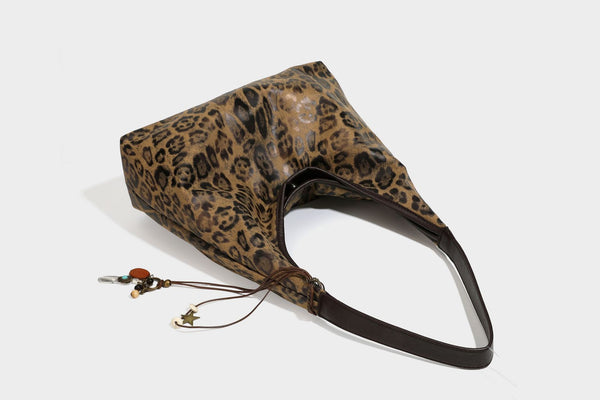 Weich fallende Hobo-Tote-Bag mit Leopardenmuster in Beige und Braun, dunkelbraunem Riemen in Lederoptik und herabhängenden Perlenanhänger-Beschlägen