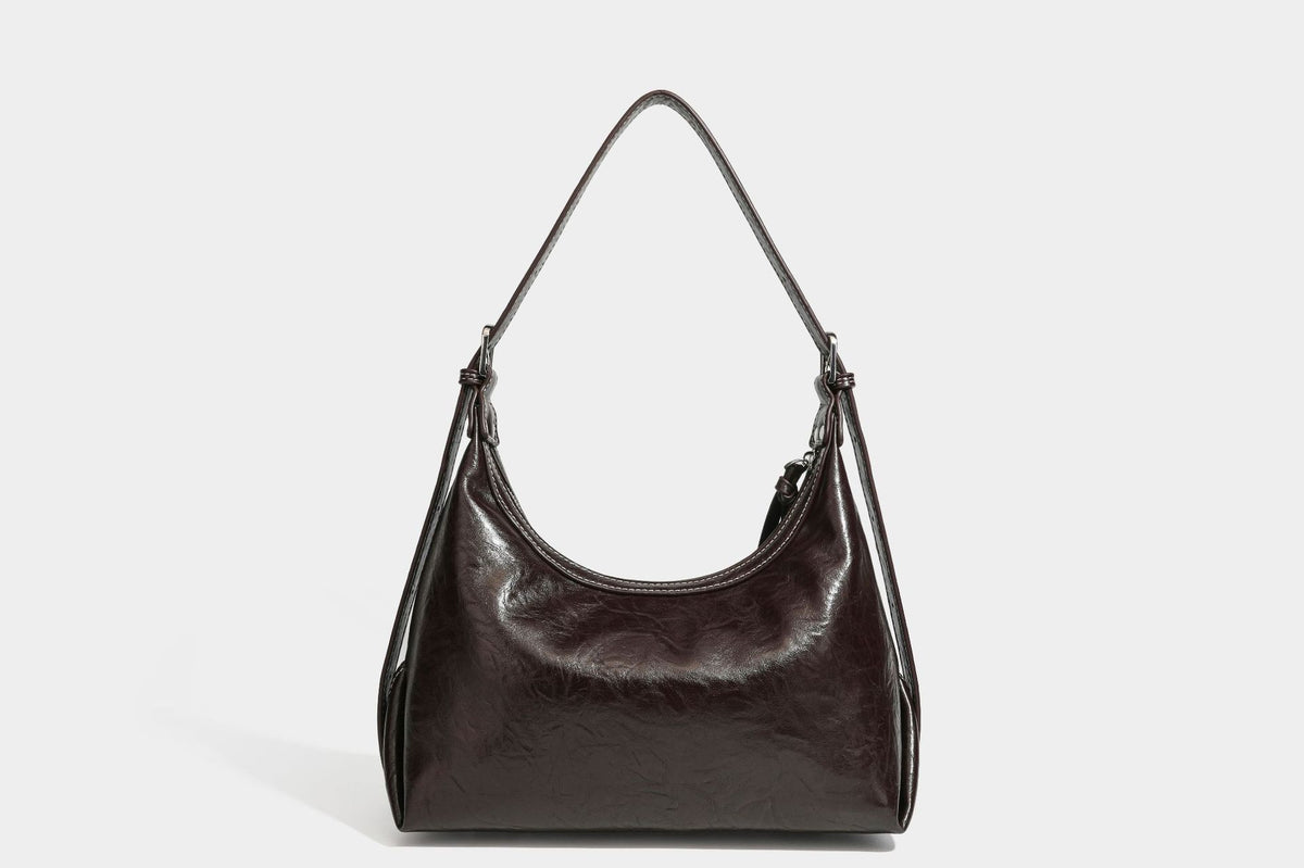 Slouchy hobo shoulder bag in glossy crinkled leather-look finish with zip-top closure and silver-tone ring hardware, detail