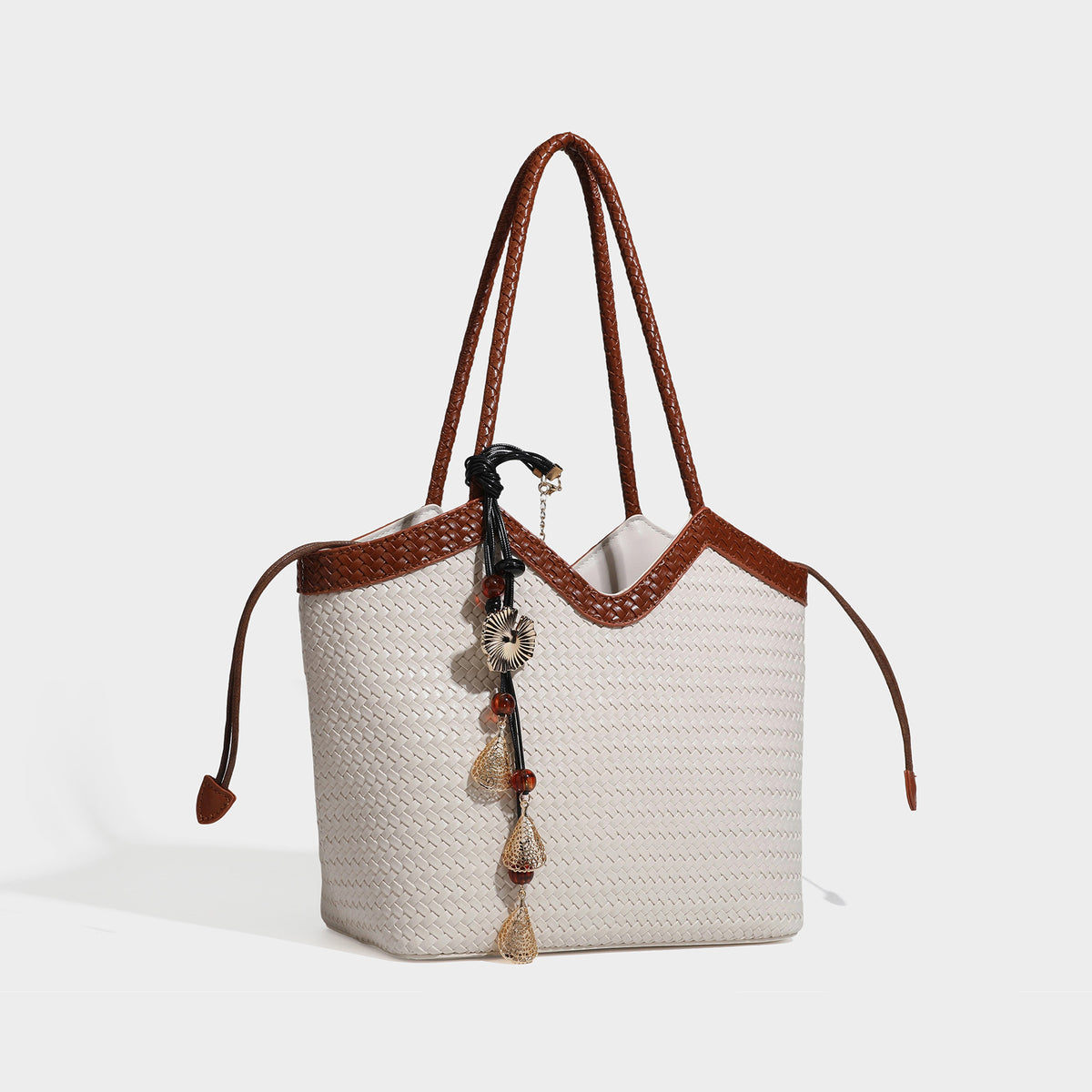 Woven tote bag with braided shoulder straps, drawstring closure, and dangling metal-and-bead charm, detail view 2