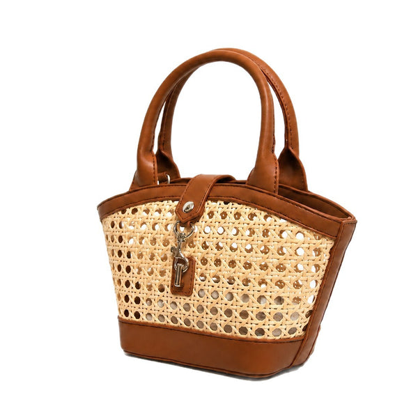 Structured mini tote bag with open-weave rattan body, leather-look arched handles and trim, front tab turn-lock closure, and