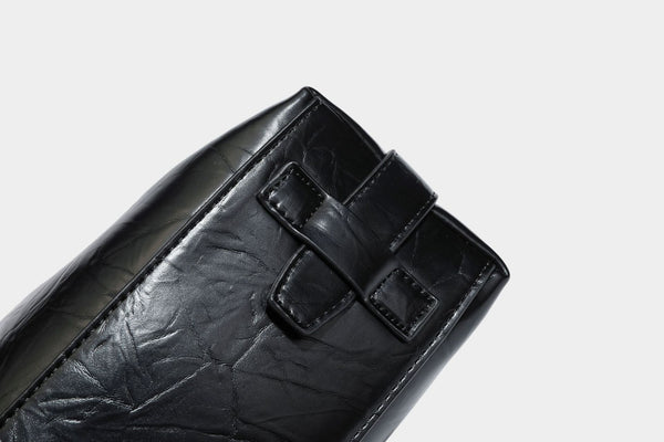 Übergroße, lässig fallende Hobo-Schultertasche aus glänzendem, geknittertem Lederimitat mit goldfarbenem Reißverschluss und Emblem-Beschlägen, Detailansicht