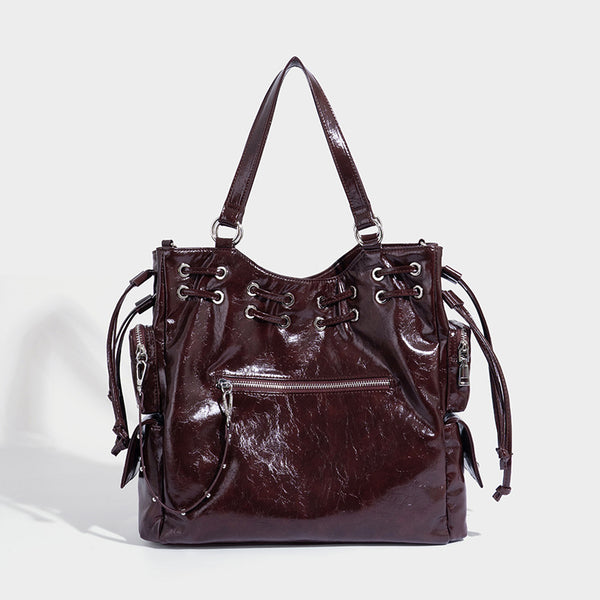 Glossy crinkled leather-look tote bag with silver grommet lace-up front detail, dual top handles, and detachable shoulder