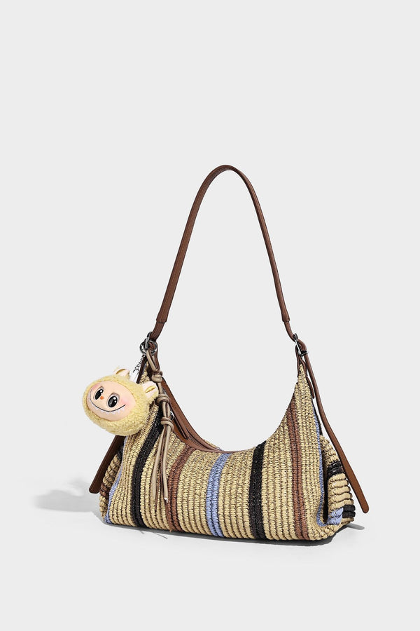 Slouchy woven straw hobo shoulder bag with beige, black, brown, and blue vertical stripes and brown leather-look trim, detail