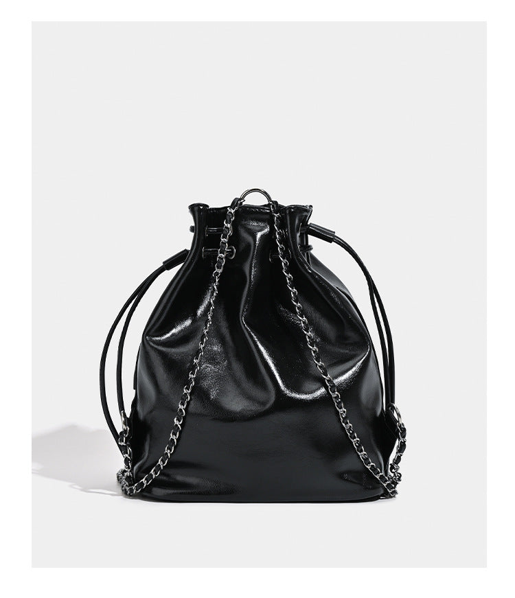 Glossy leather-look drawstring bucket bag with silver dome studs and chain shoulder strap, detail view 13