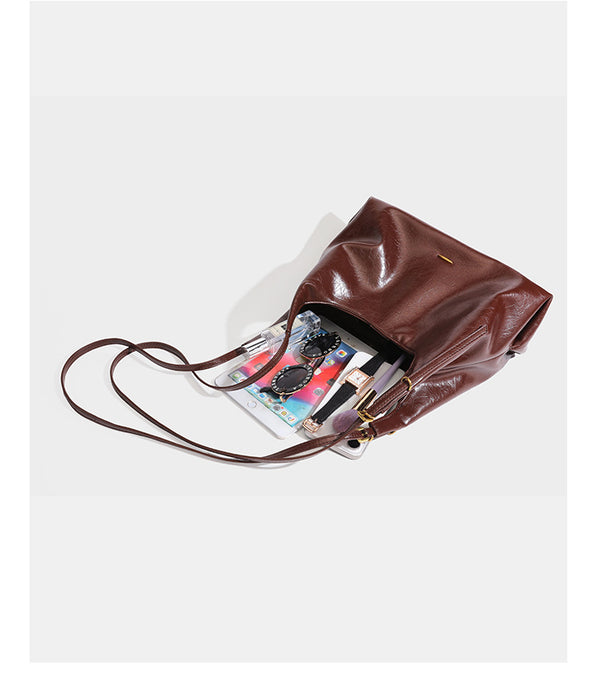 Locker fallende Hobo-Schultertasche mit offenem Oberteil aus glänzendem, geknautschtem Lederimitat in Dunkelbraun, mit schmalem verstellbarem Riemen und goldfarbenem