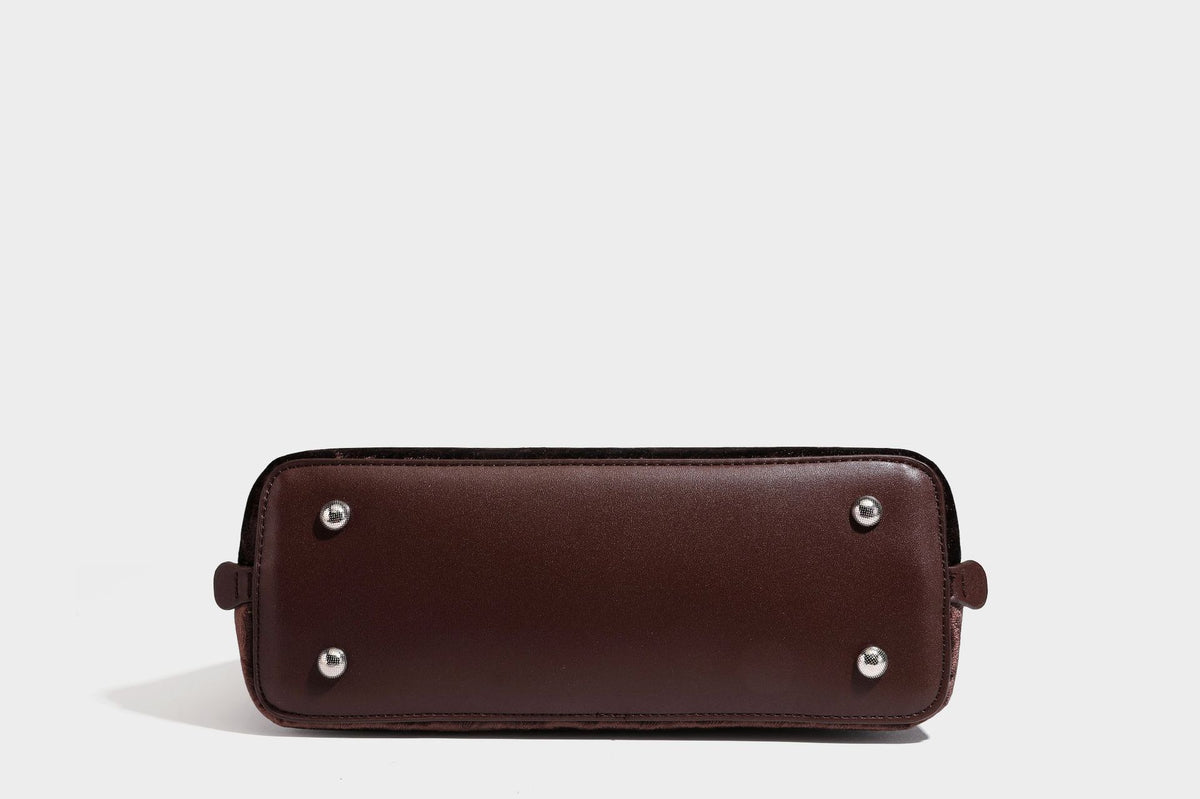 Small structured satchel bag in dark brown velvet-like textured finish with leather-look trim, silver-tone turn-lock bar