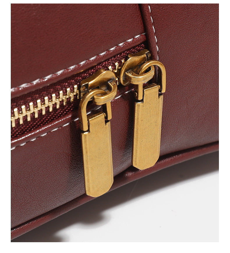 Structured rectangular leather-look shoulder bag with top zip, tassel and resin ring charm, and contrast topstitching, detail