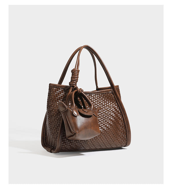 Strukturierte Tote-Bag mit Webstruktur in Braun, glattem, lederähnlichem Besatz, geknoteten Tragegriffen und einer befestigten Mini-Beuteltasche mit Kordelzug