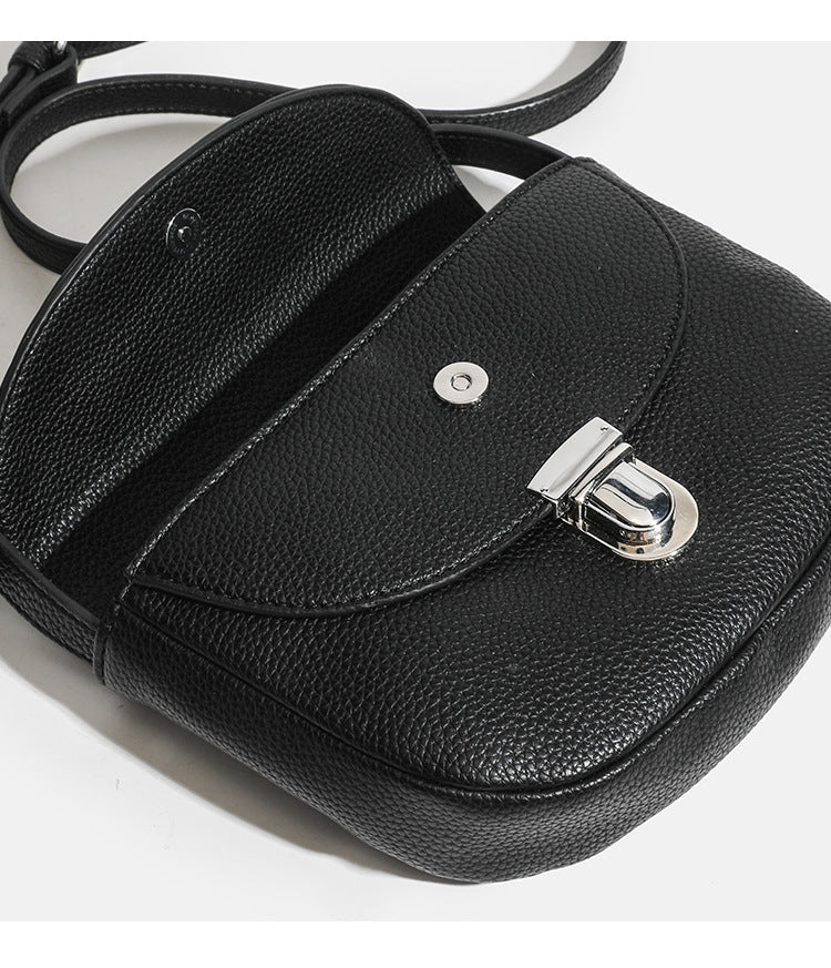 Mini-Crossbody-Satteltasche mit genarbter Oberfläche, silberfarbenem Drehverschluss an der Klappe und verstellbarem Schulterriemen, Detailansicht 10