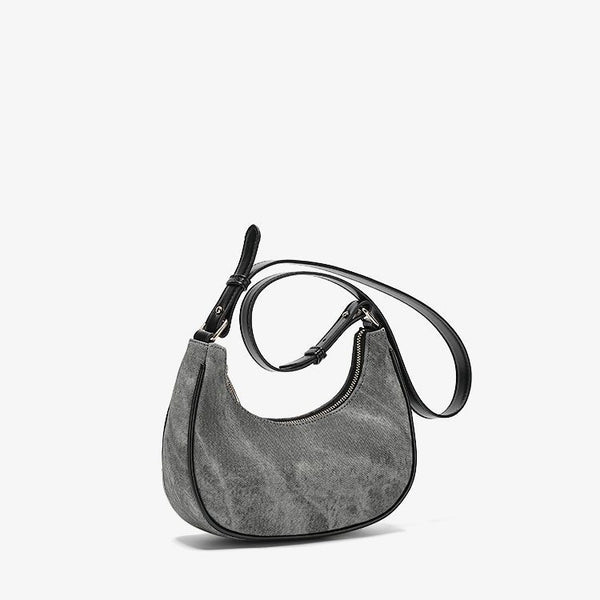 Small gray crescent half-moon shoulder bag with black leather-look trim, gold-tone zipper, and adjustable slim strap, detail
