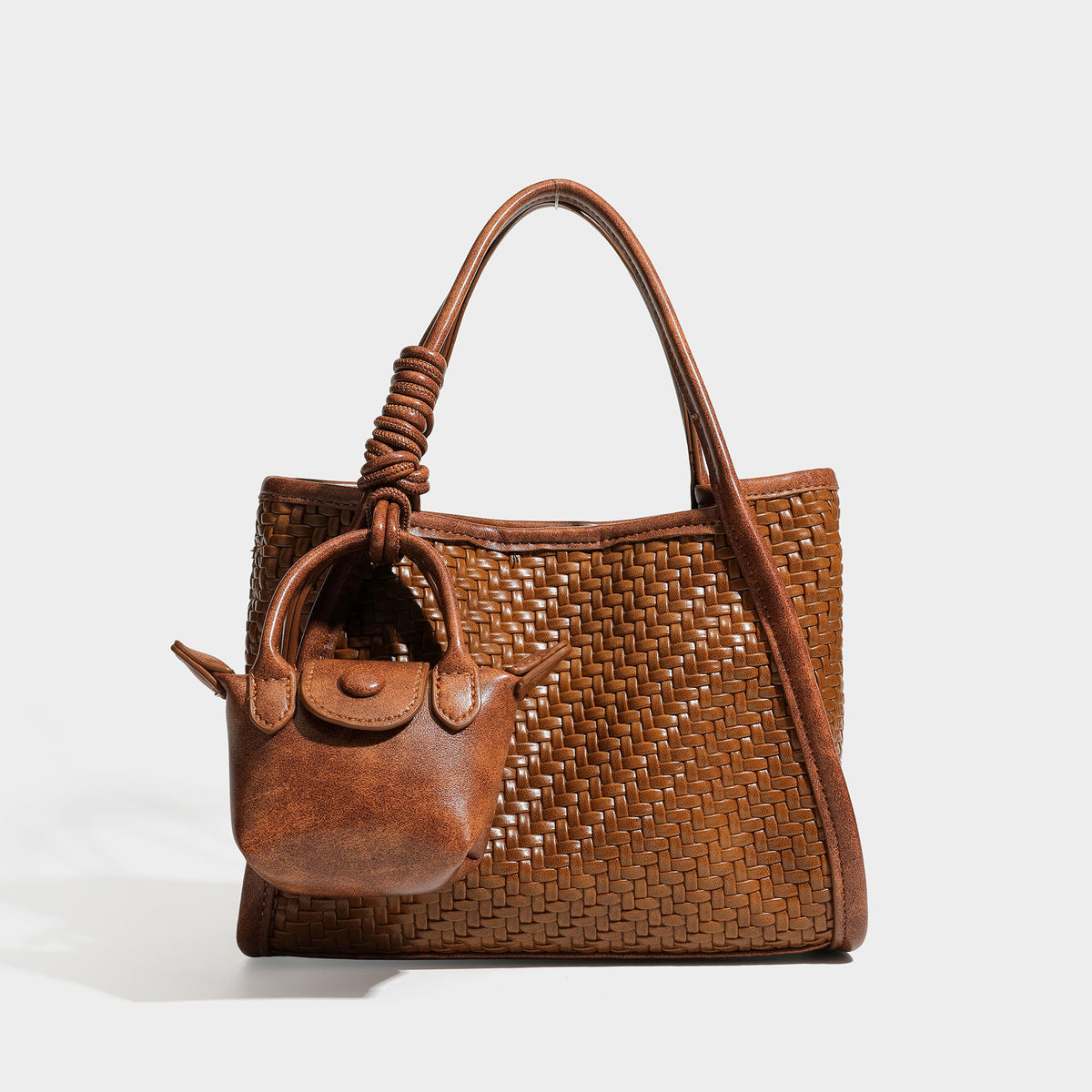 Strukturierte Tote Bag mit Webstruktur in Braun, glatten Besätzen in Lederoptik, geknoteten Tragegriffen und befestigtem Mini-Beutel mit Kordelzug