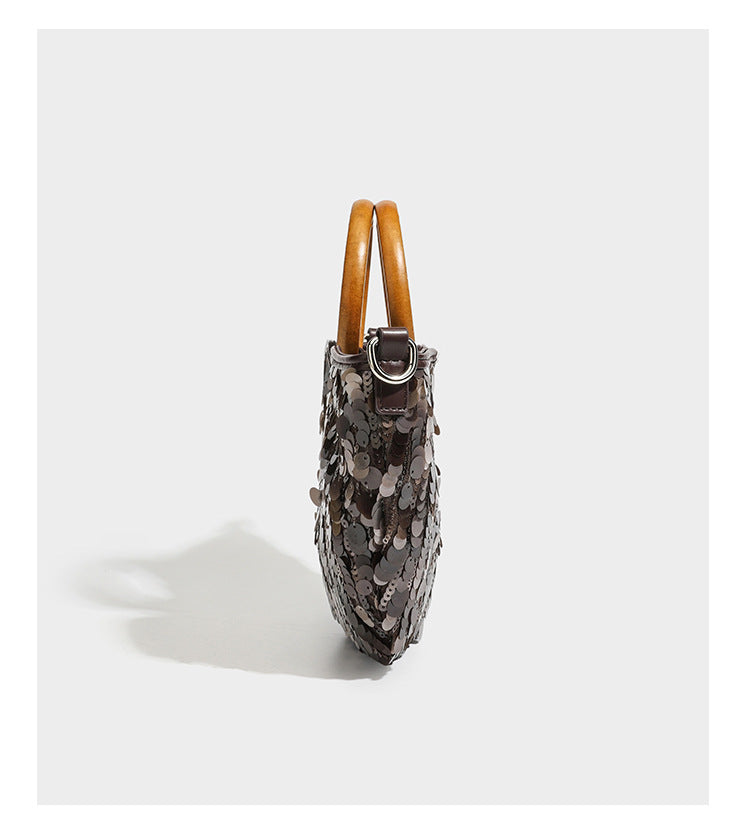 Small sequin half-moon handbag with circular wood-look ring handles and detachable leather-look shoulder strap, detail view