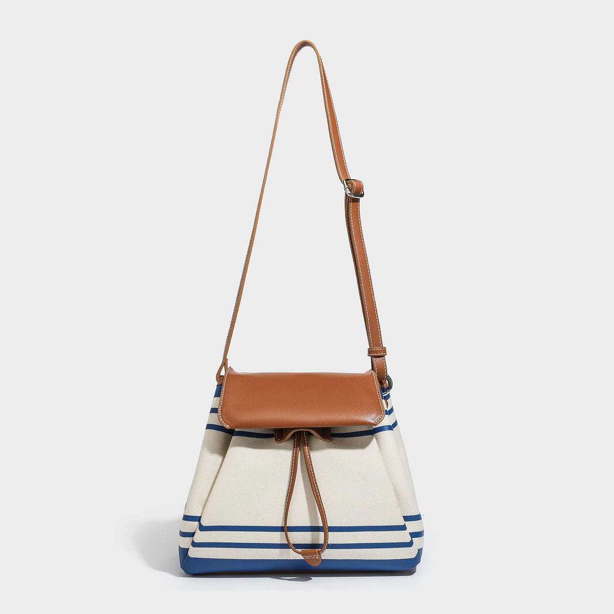 Cream canvas bucket bag with blue horizontal stripes, tan leather-look flap and trim, drawstring closure, silver-tone, detail