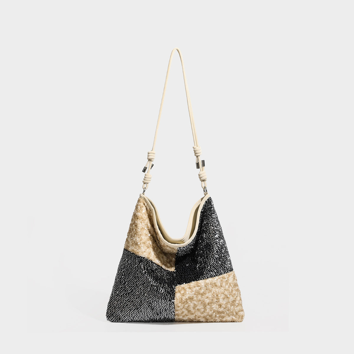 Slouchy patchwork sequin shoulder tote bag with colorblock black-gold or cream-silver panels and adjustable slim strap, front