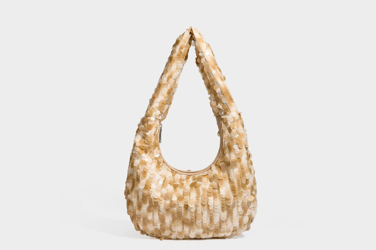 Slouchy crescent hobo shoulder bag covered in overlapping reflective sequin discs with a single integrated strap and top-zip