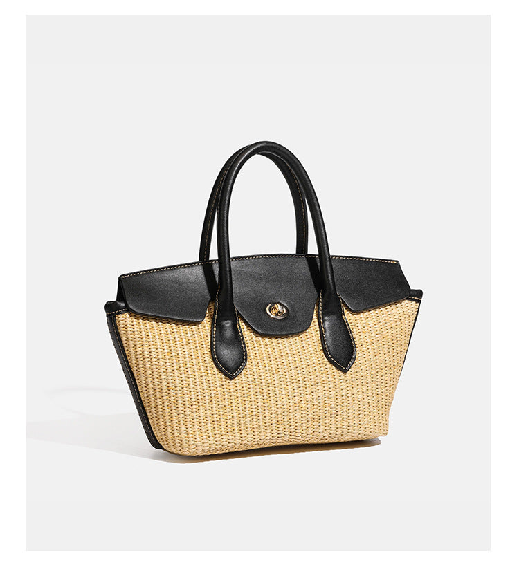 Structured tan woven straw tote bag with black leather-look trim, twin rounded top handles, gold-tone turn-lock front flap