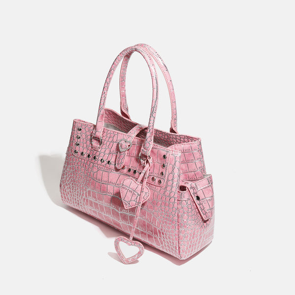 Blush pink glossy crocodile-embossed structured tote bag with studded trim, silver-tone hardware, double top handles, and