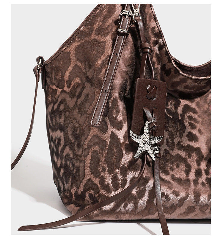 Große, glänzende Hobo-Schultertasche mit Leopardenprint, abnehmbarem Reißverschlusstäschchen und silberfarbenem Seestern-Anhänger, Detailansicht