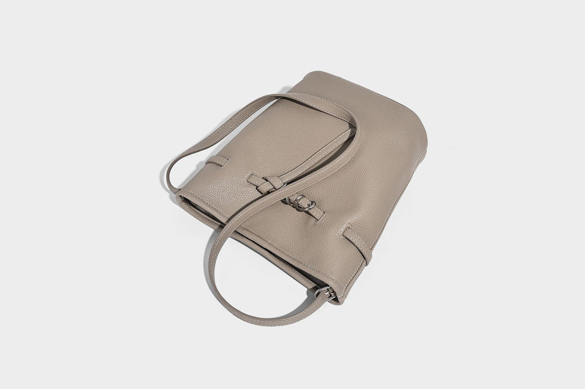 Small pebbled leather-look bucket bag with front drawstring toggle hardware and long adjustable shoulder strap, detail view