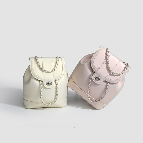 Small pearl-gloss backpack handbag with woven silver chain straps and turn-lock flap closure, detail view 2