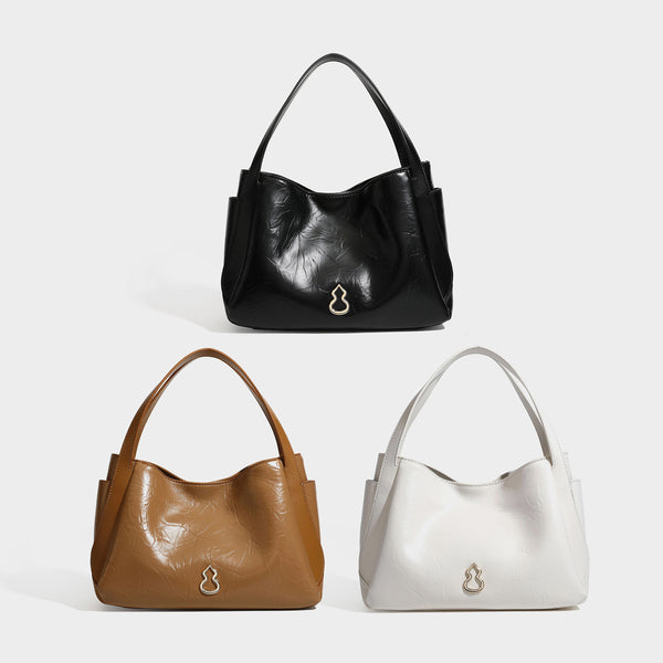 Black glossy crinkled leather-look convertible shoulder tote bag with gold gourd-shaped emblem hardware and detachable